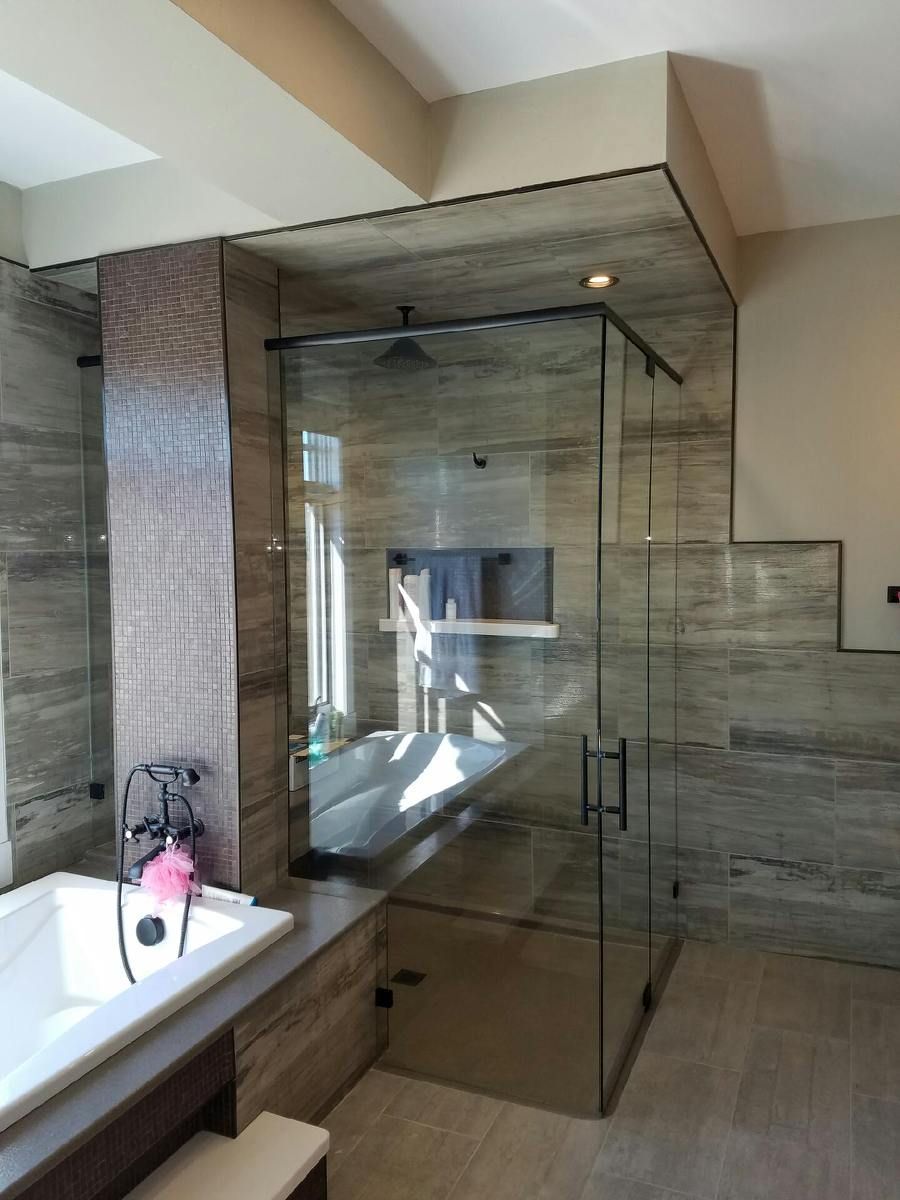 Modern bathroom with a glass-enclosed shower, vanity sink, and beige tiled walls and floor