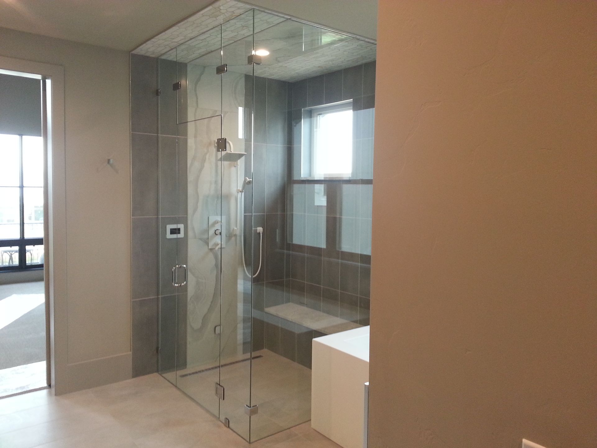 Modern bathroom with a glass shower enclosure, wall-mounted shower, and neutral-toned walls.