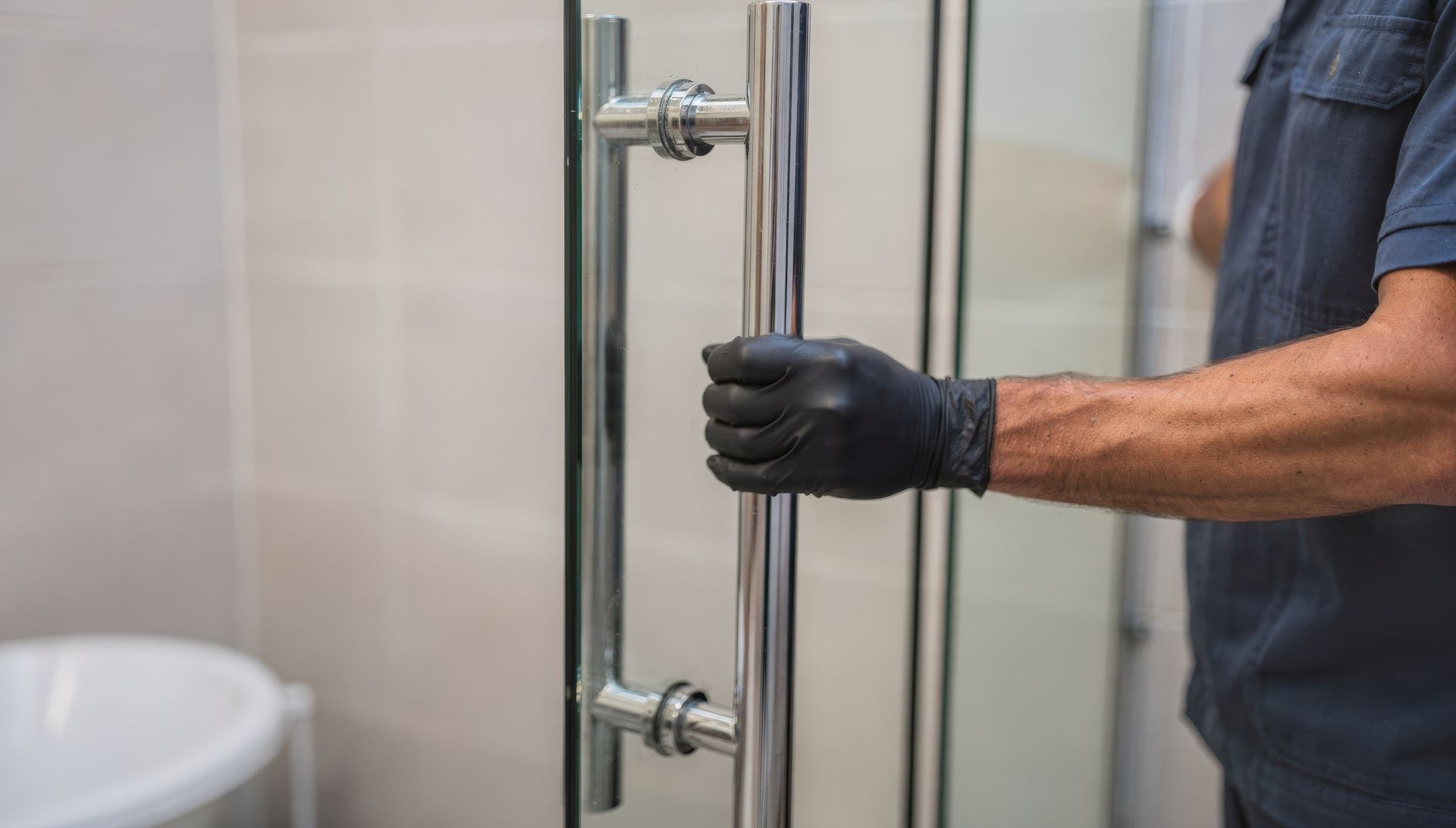 Custom shower door installation with frameless glass panel and modern hardware finish