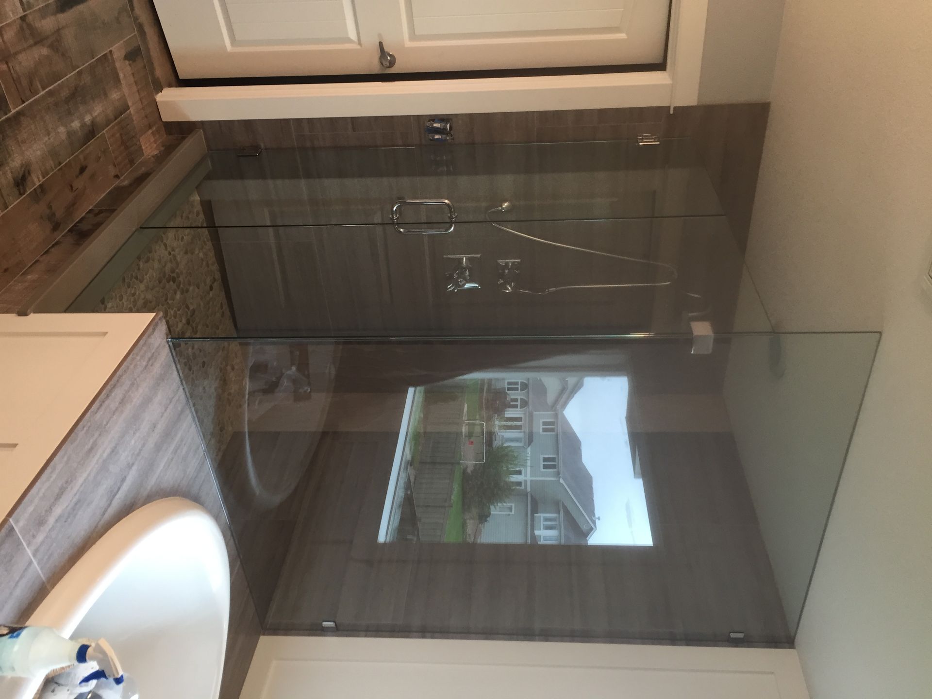 Modern bathroom with a wall-mounted mirror above a dark vanity and white sink.