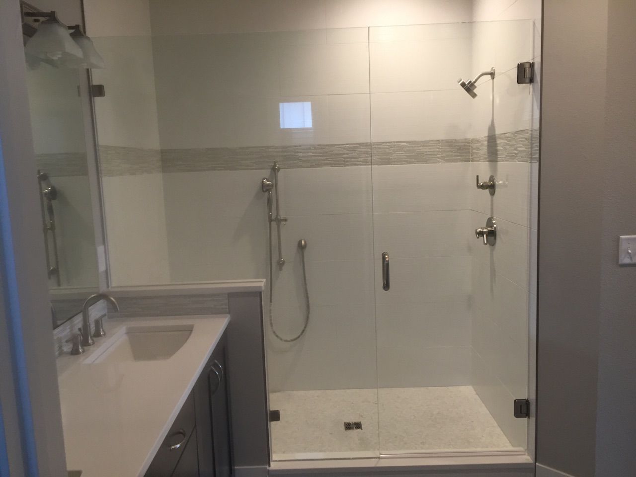 Modern bathroom with glass-enclosed walk-in shower and white vanity sink