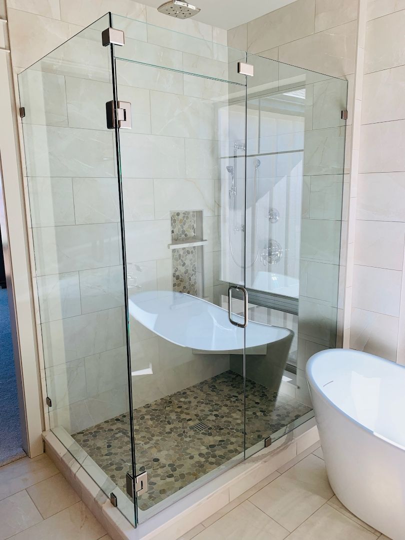 Modern bathroom with glass-enclosed shower, white tub, and mosaic tile floor