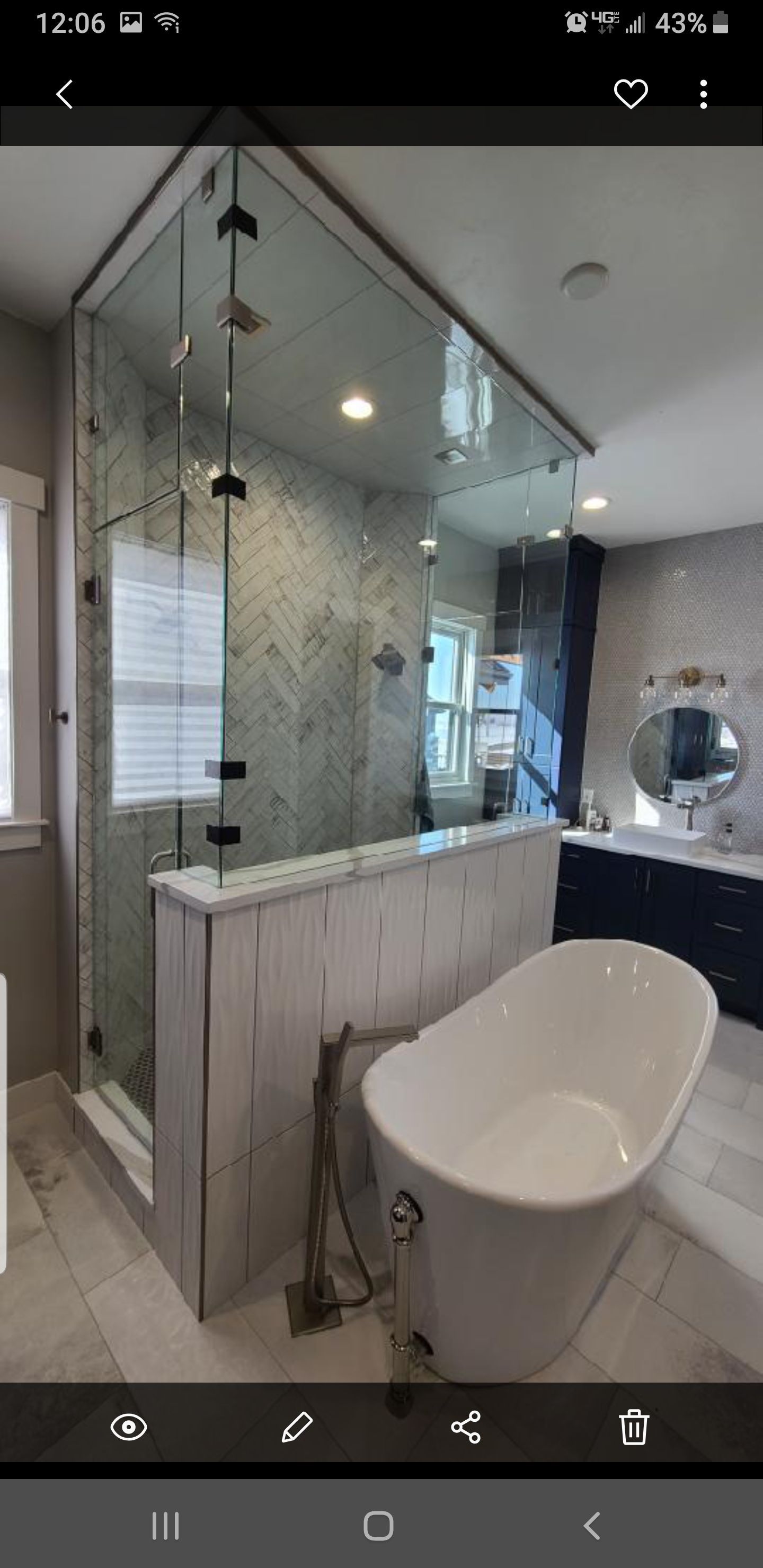 Modern bathroom with freestanding tub, glass shower, and mirrored vanity in white and gray tones