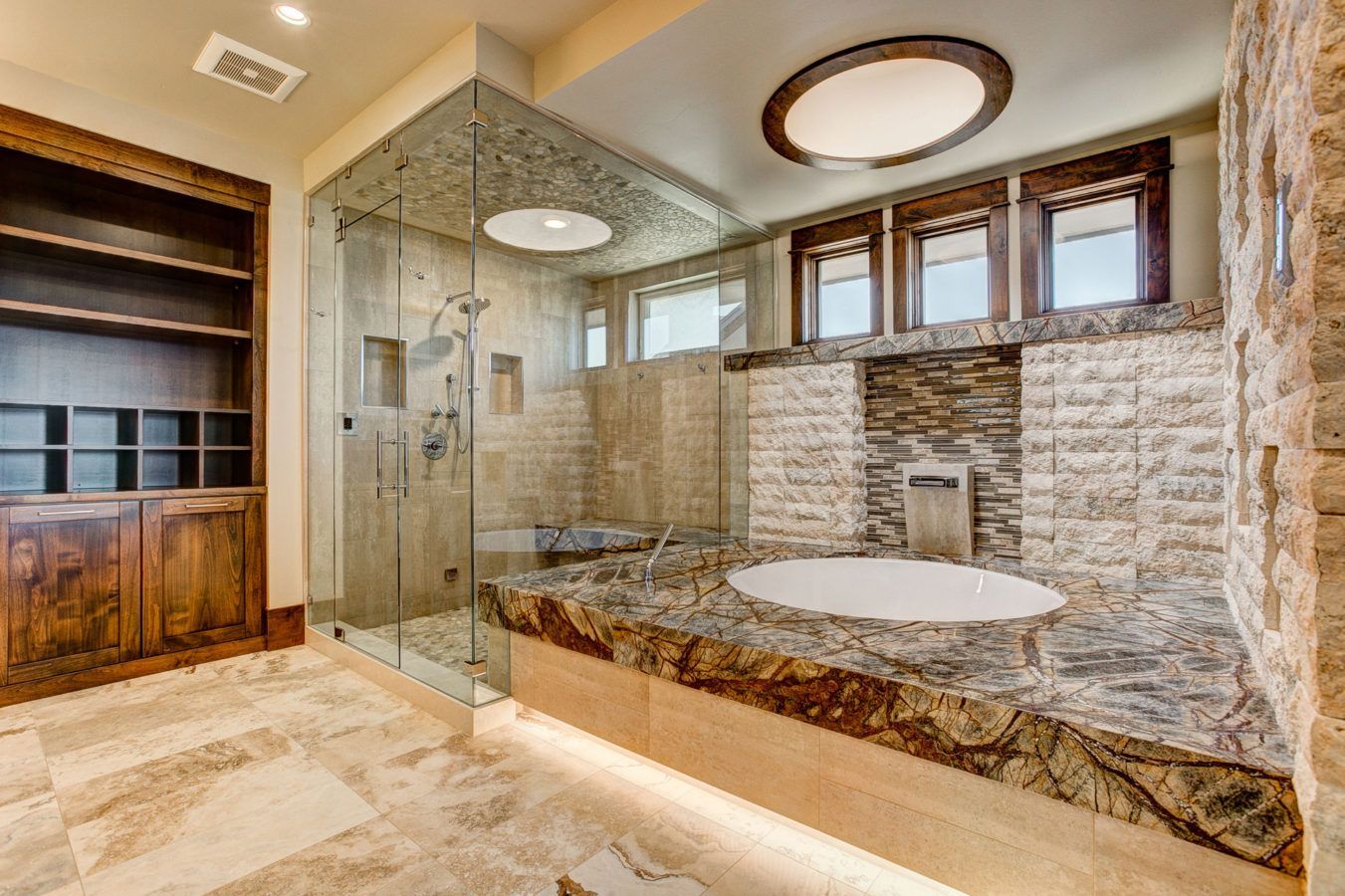 Luxury bathroom with stone tub, glass shower, and warm wood accents