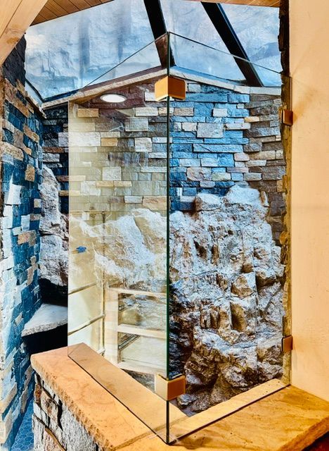Glass-framed stone display with blue and tan layered rock textures in a museum-like setting