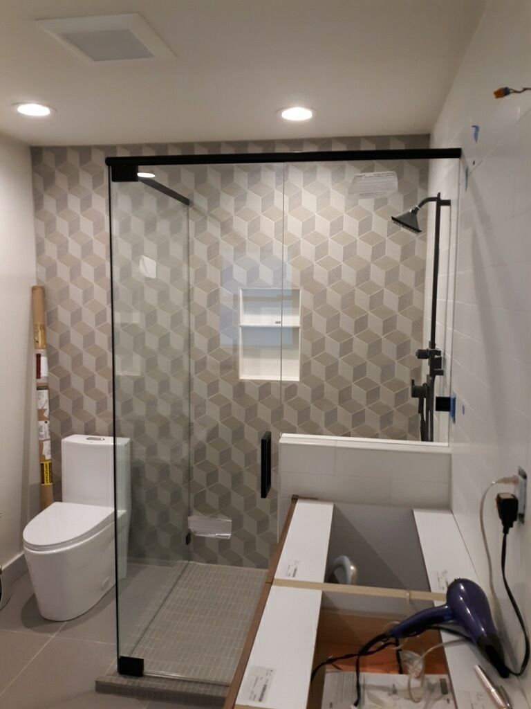 Accessible bathroom with walk-in shower, toilet, grab bars, and sink under construction