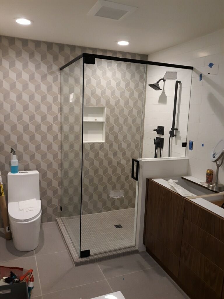 Accessible bathroom with roll-in shower, wall-mounted sink, and toilet beside a wood vanity.