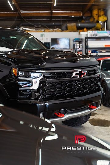 A black chevy truck is parked in a garage.