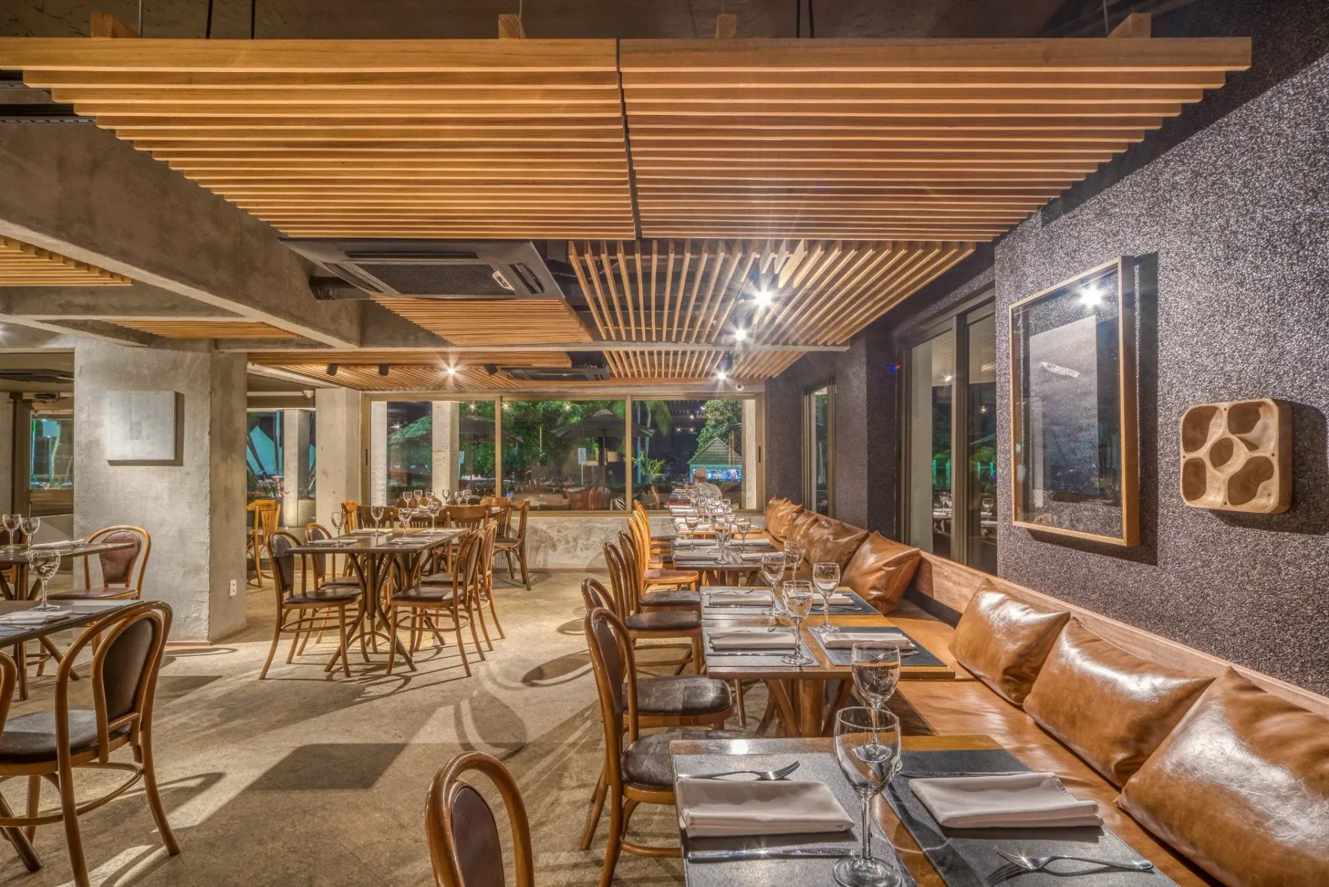 Uma grande sala de jantar com mesas e cadeiras e um teto de madeira.