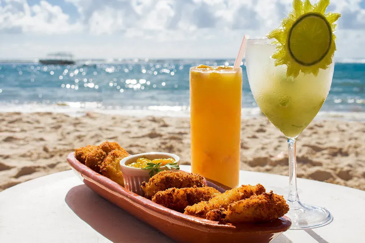 Petiscos empanados  e drinks refrescantes, amarelo e verde, com a vista do mar da Praia do Francês 