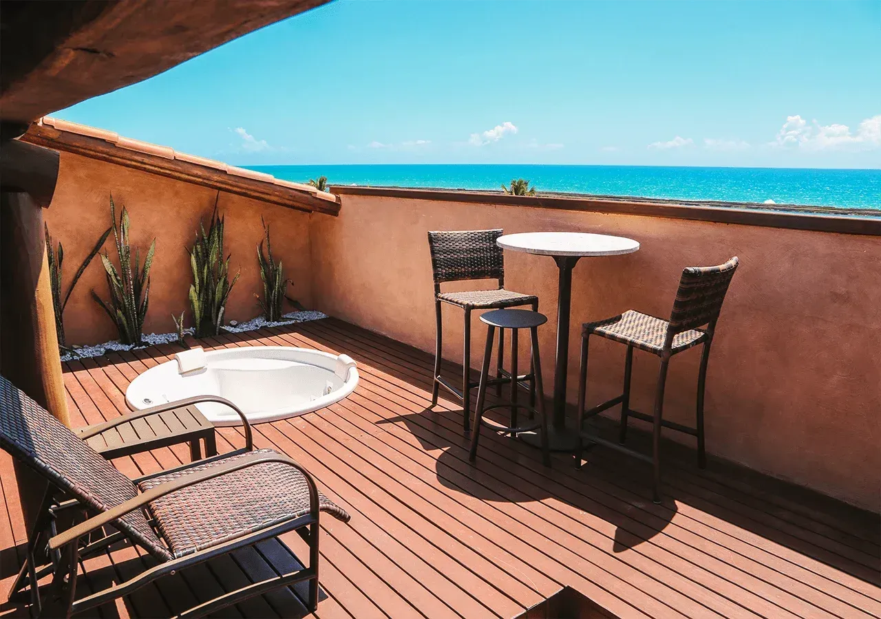 Uma varanda com mesa e cadeiras com vista para o oceano.