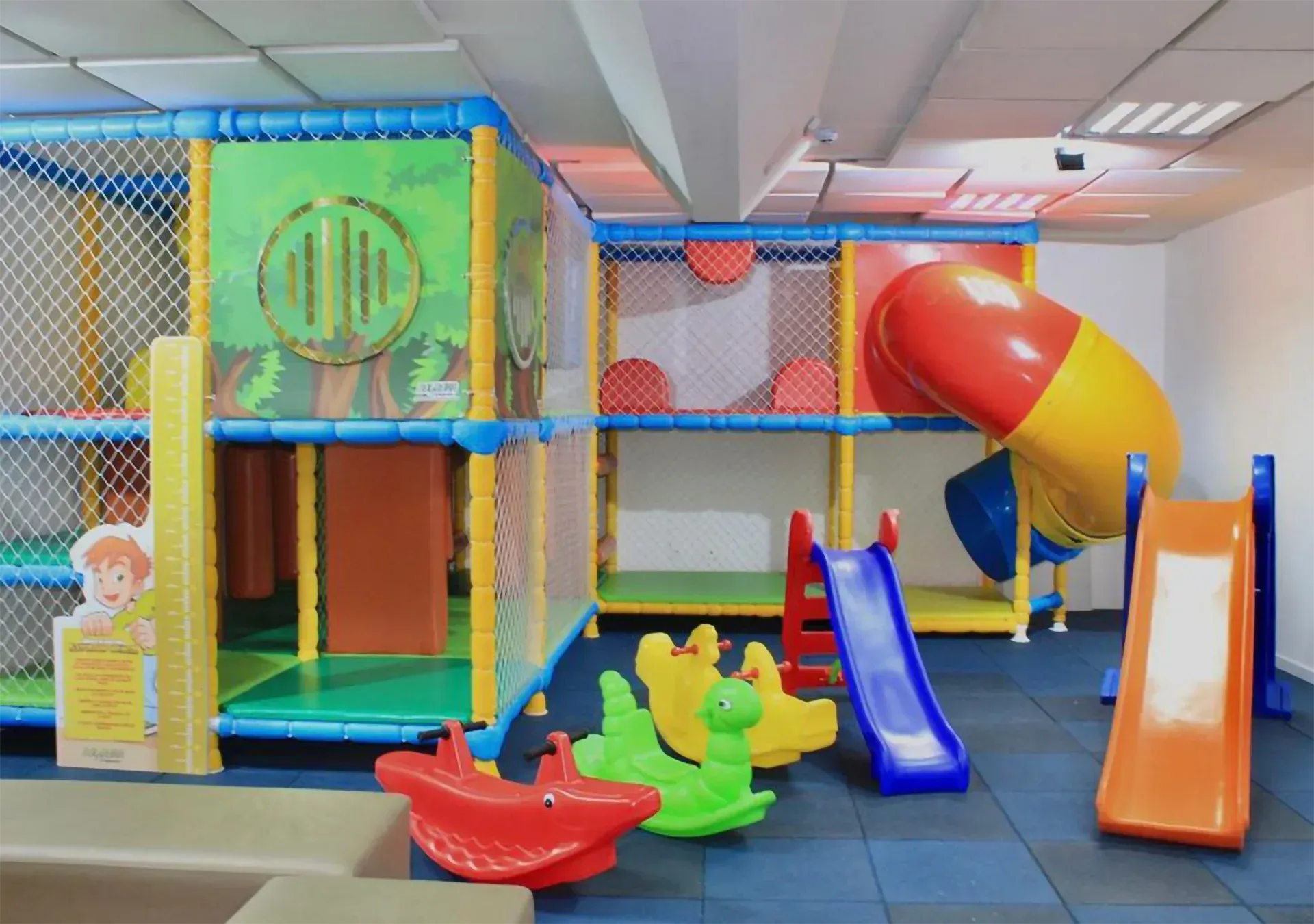 Um parque infantil com escorregador e cavalos de balanço