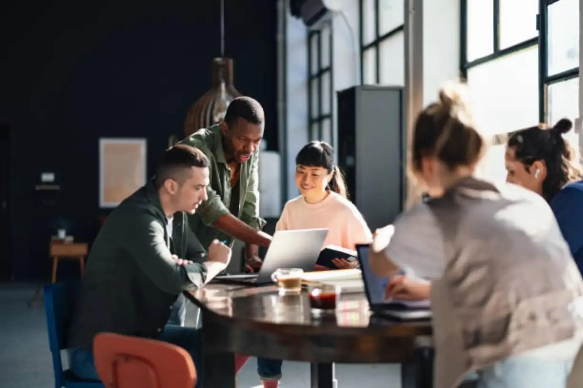 Employees meeting at a table discussing work decisions during year-end layoffs, highlighting potential wrongful termination issues in Colorado workplaces