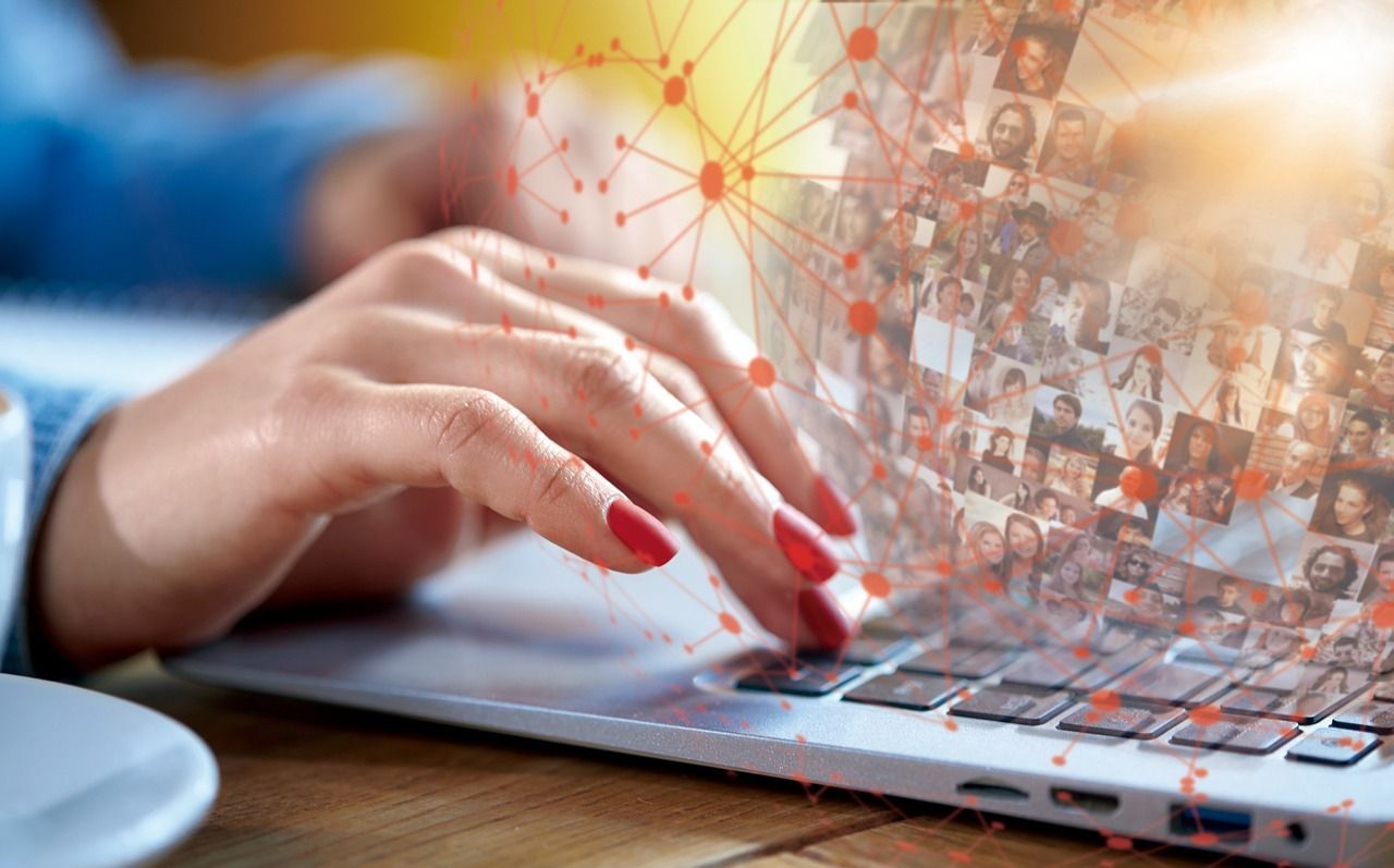 Close-up of hands typing on a laptop with a digital network overlay and candidate profile images, symbolizing AI-powered hiring and recruitment screening in Colorado.