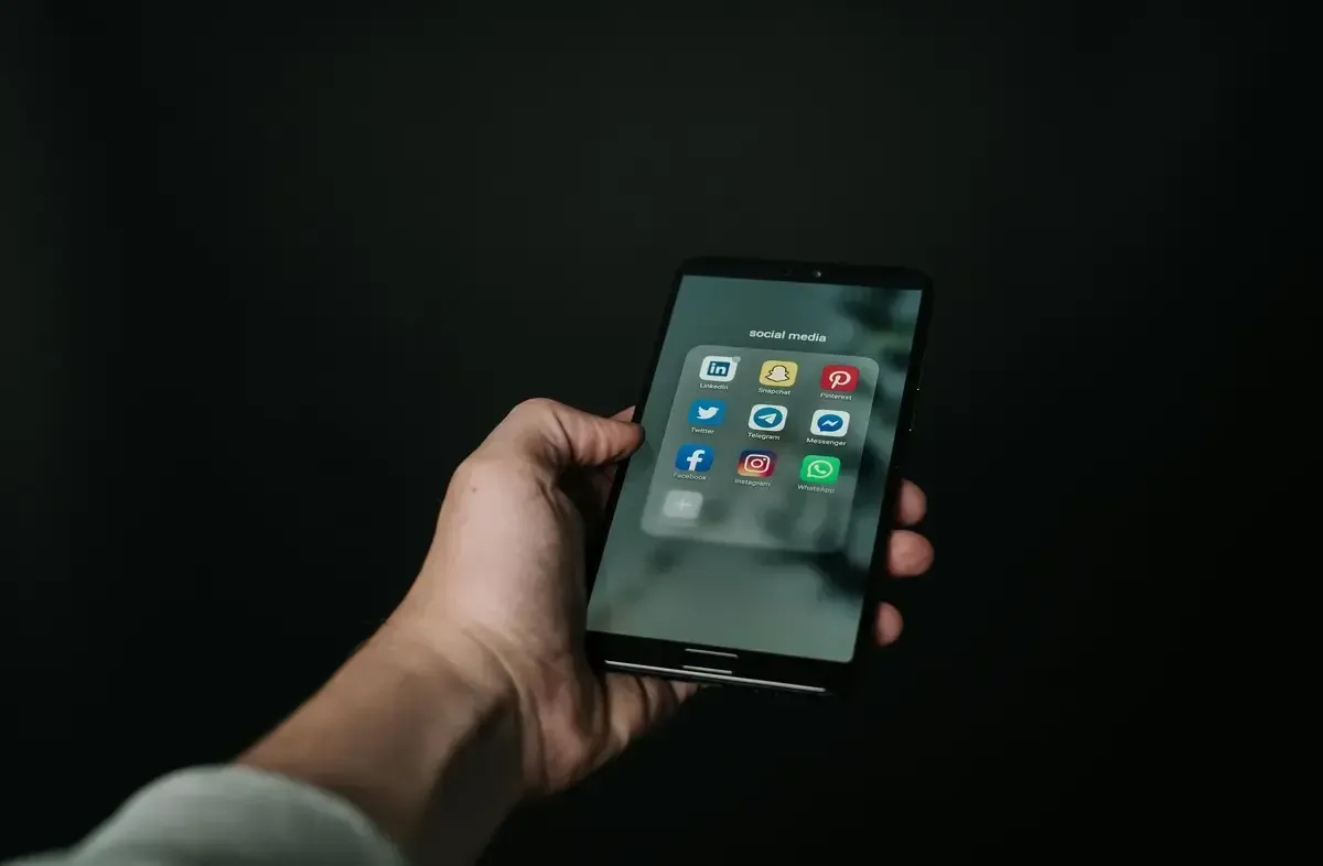 Smartphone screen displaying popular social media apps like Facebook, Twitter, LinkedIn, and Instagram, representing the risks employees face posting online under Colorado employment law.