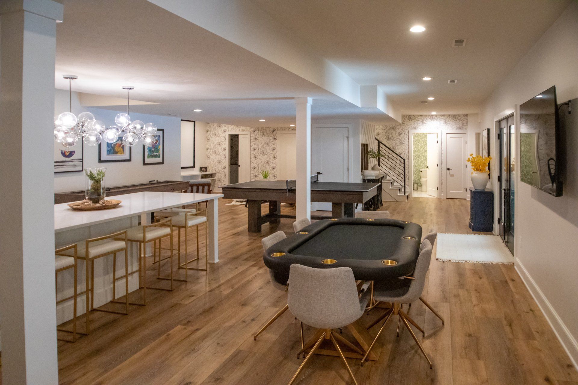 Spacious finished basement with a poker table, pool table, bar area, and multiple seating areas.