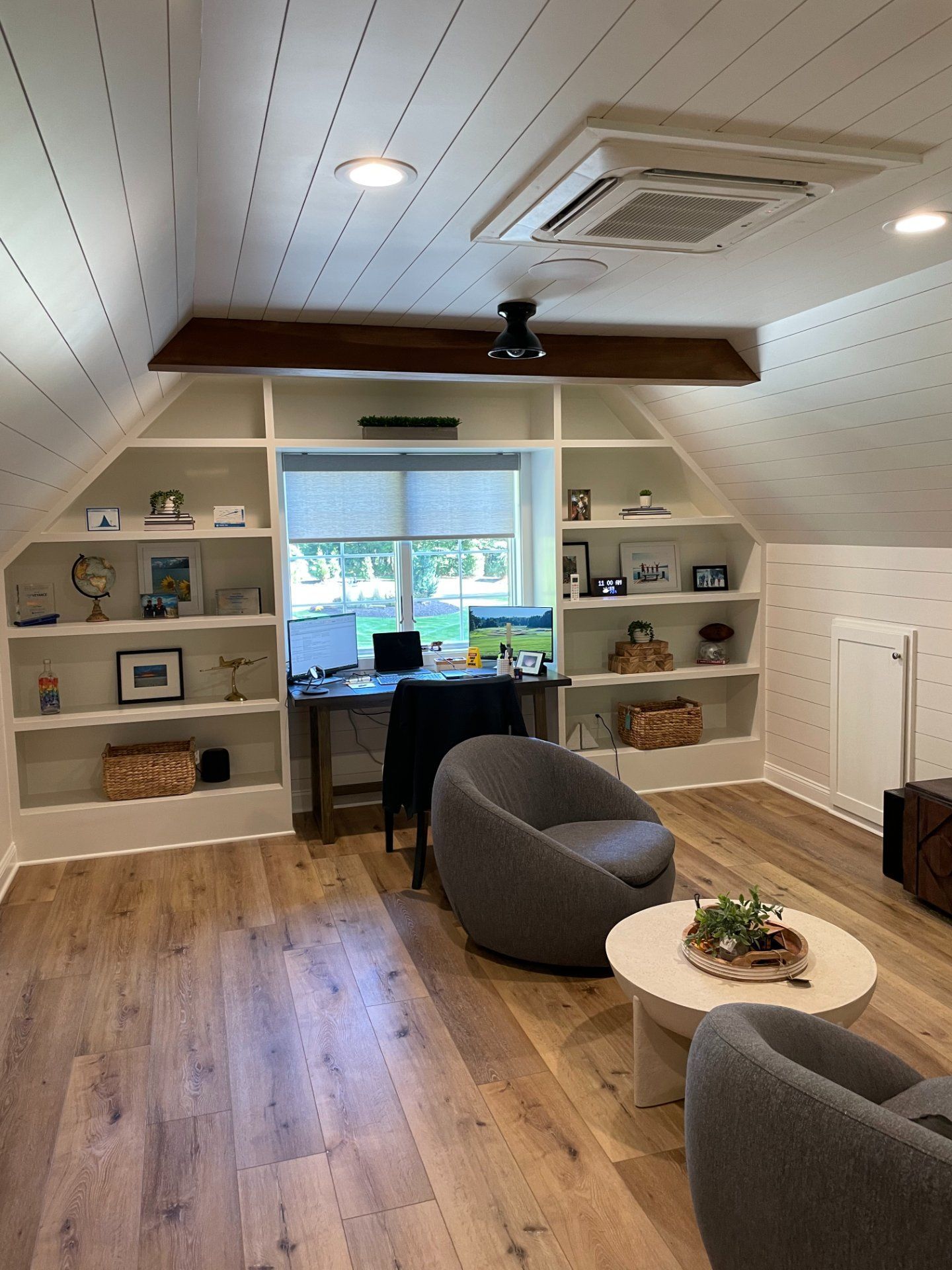 Cozy home office with built-in shelves, a desk, and two gray beanbag chairs.