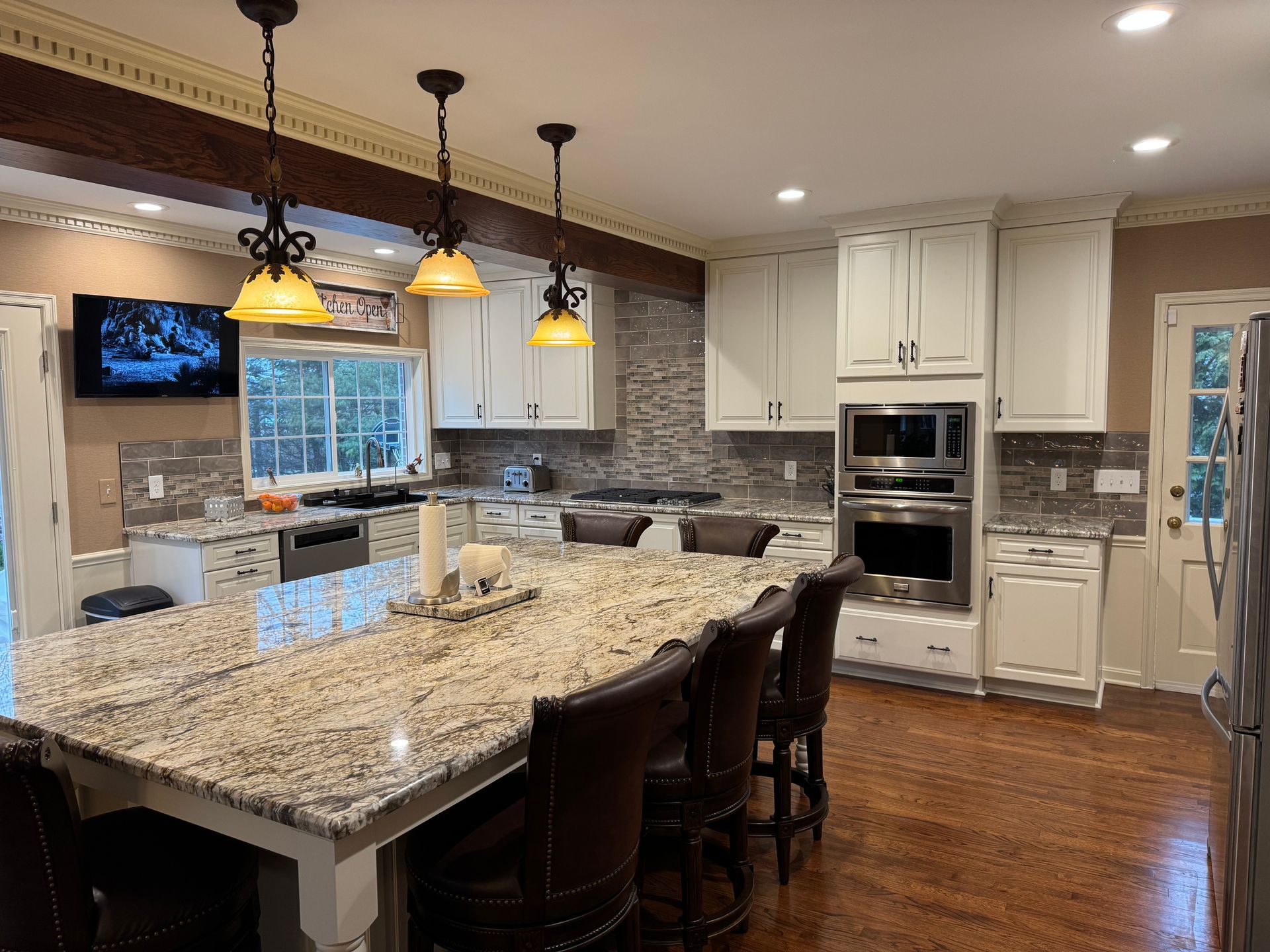 Kitchen with a large island, white cabinets, and granite countertops.