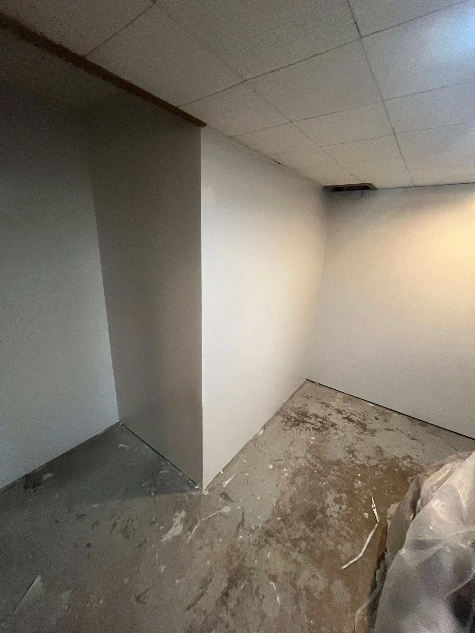 An empty room with white walls and a ceiling.