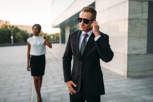 security man holding phone while client in background