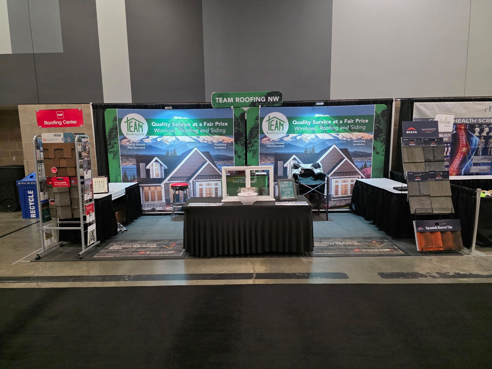 Trade show booth with window samples, promotional banners, and product displays.