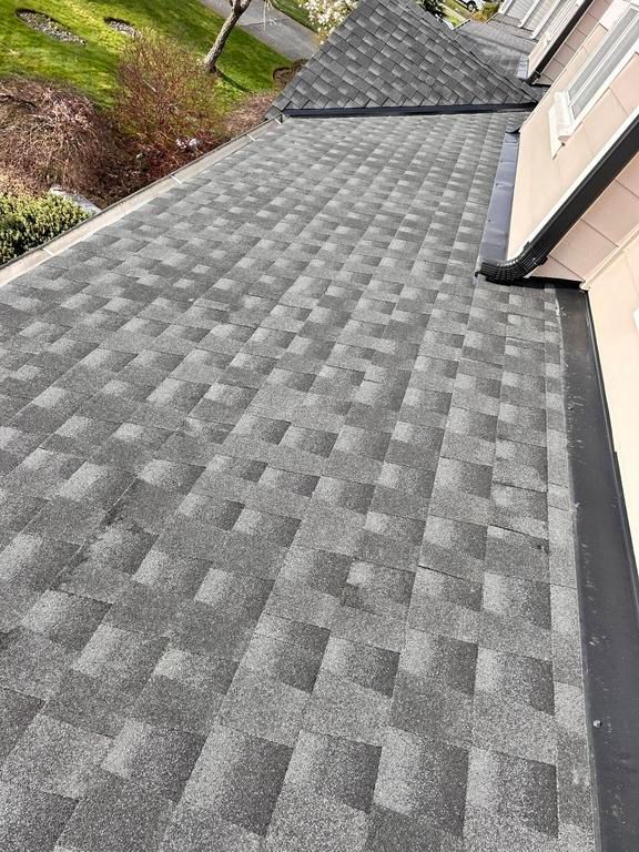 Gray asphalt shingle roof on a residential building. A gutter runs along the edge.