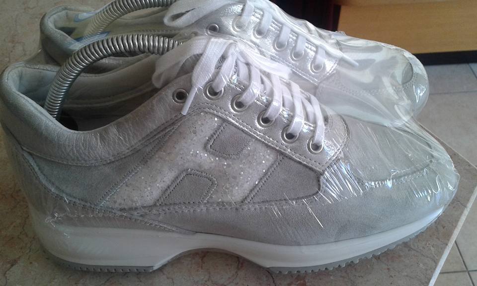 Un paio di scarpe da ginnastica bianche sono appoggiate su un tavolo.