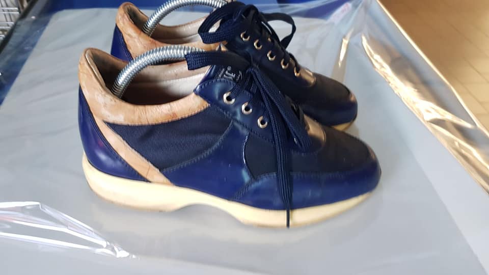 Un paio di scarpe blu e marroni appoggiate su un tavolo