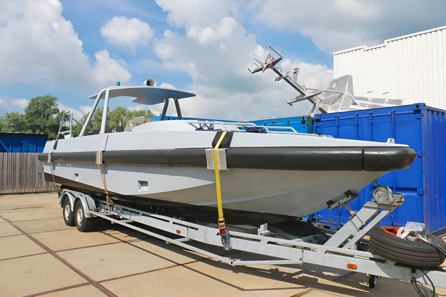 Boat is Sitting on a Trailer Next to a Blue Container — BCV Storage Centre in Wauchope, NSW