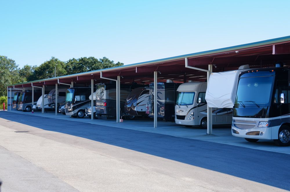 Row of vehicles parked under a long, red-roofed awning at a storage facility — BCV Storage Centre in Port Macquarie, NSW