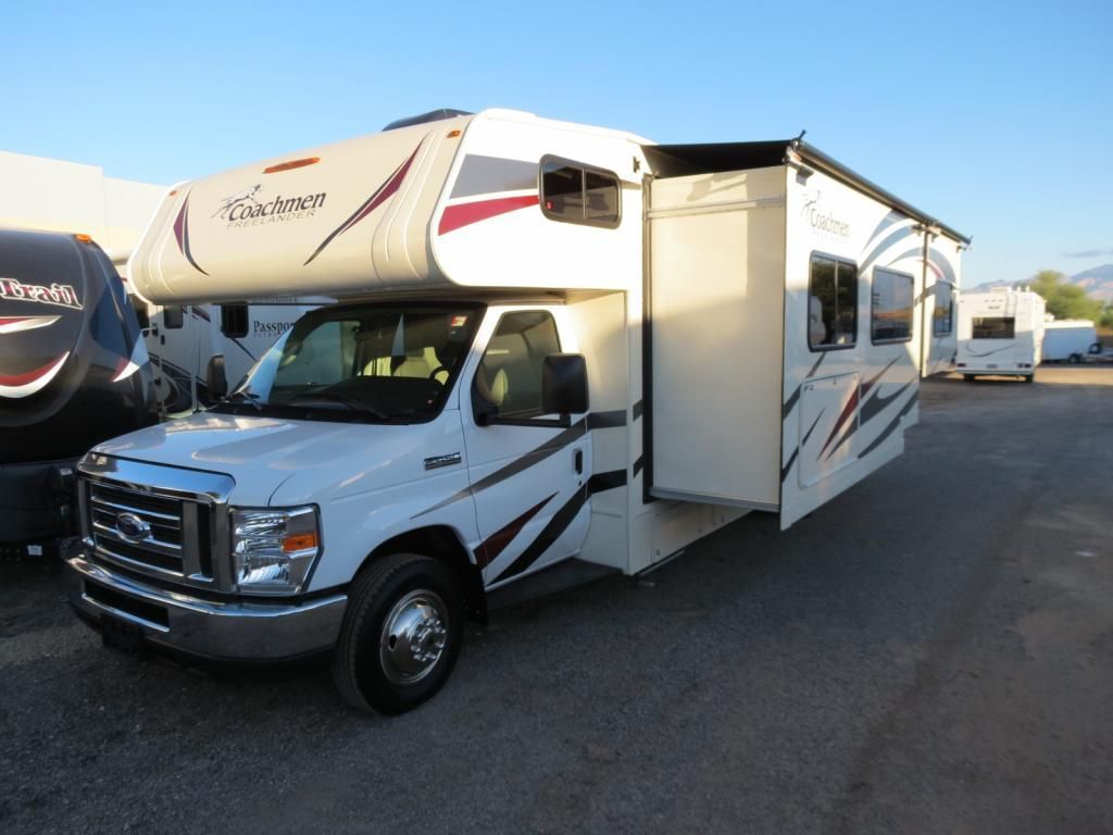 A white rv is parked in a parking lot.
