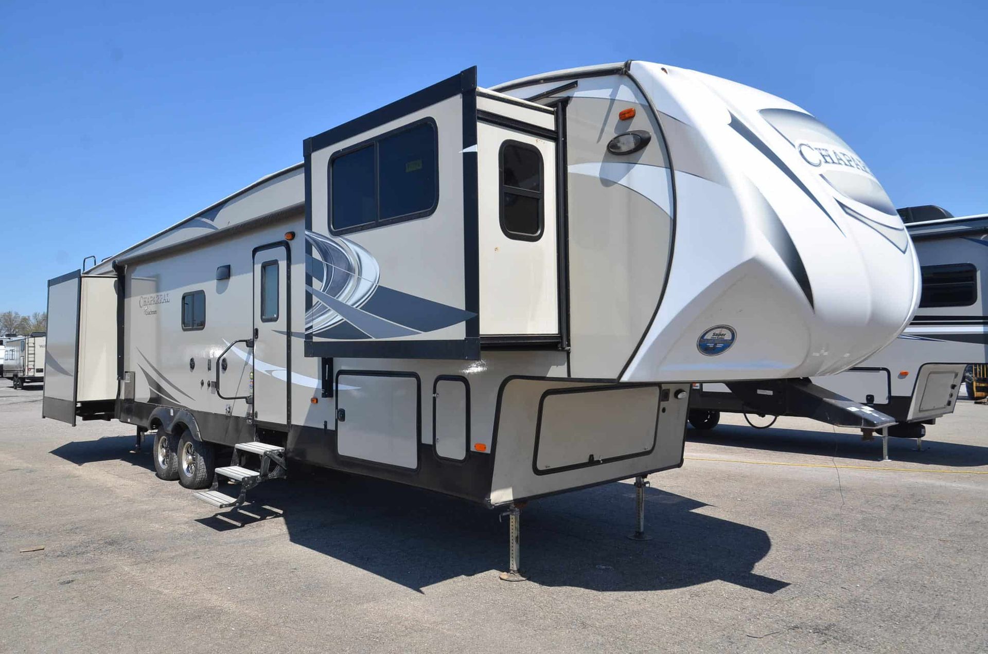 A white and black rv is parked in a parking lot.