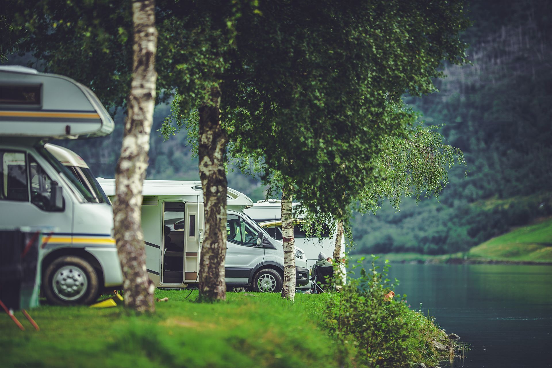 Row of RVs Parked Beside the Lake