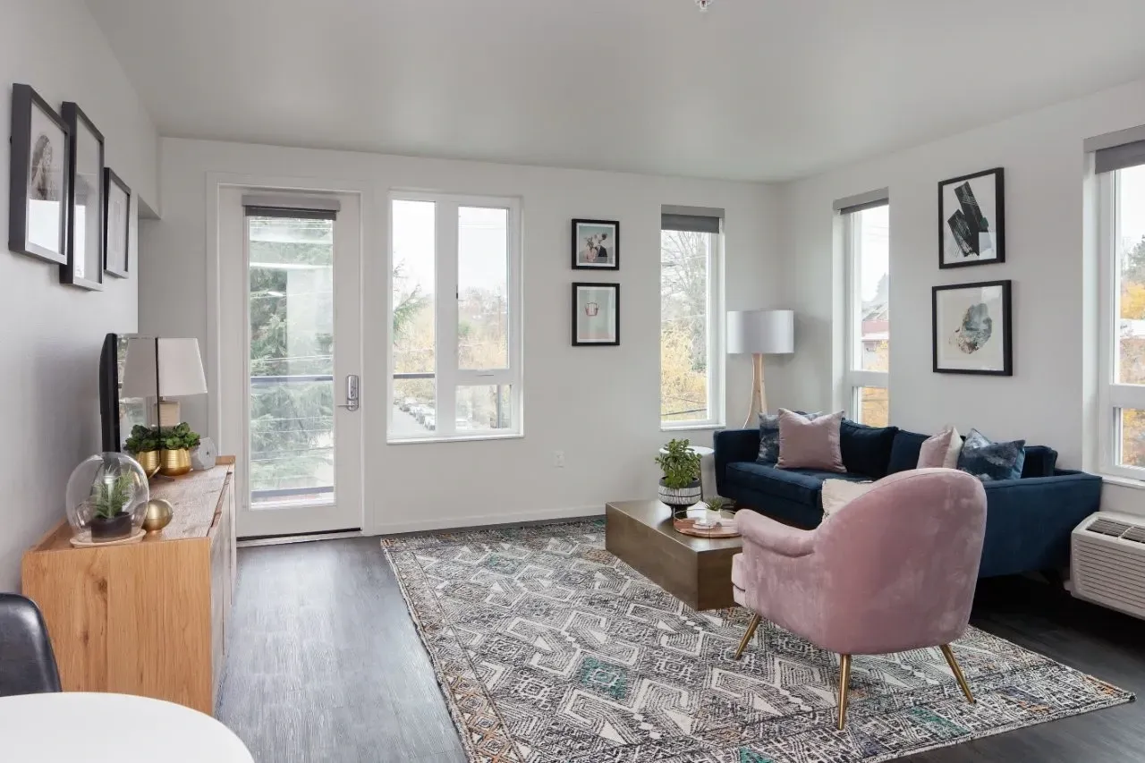A living room with a pink chair and a blue couch.