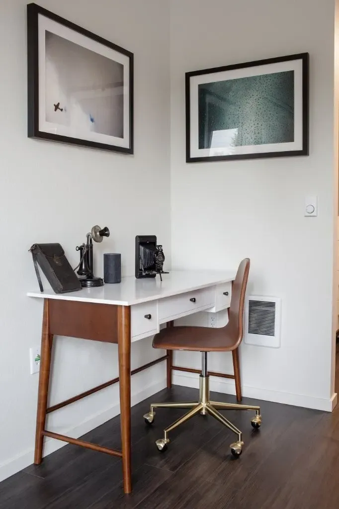 A stylish desk with vintage accessories and a modern chair in an apartment.
