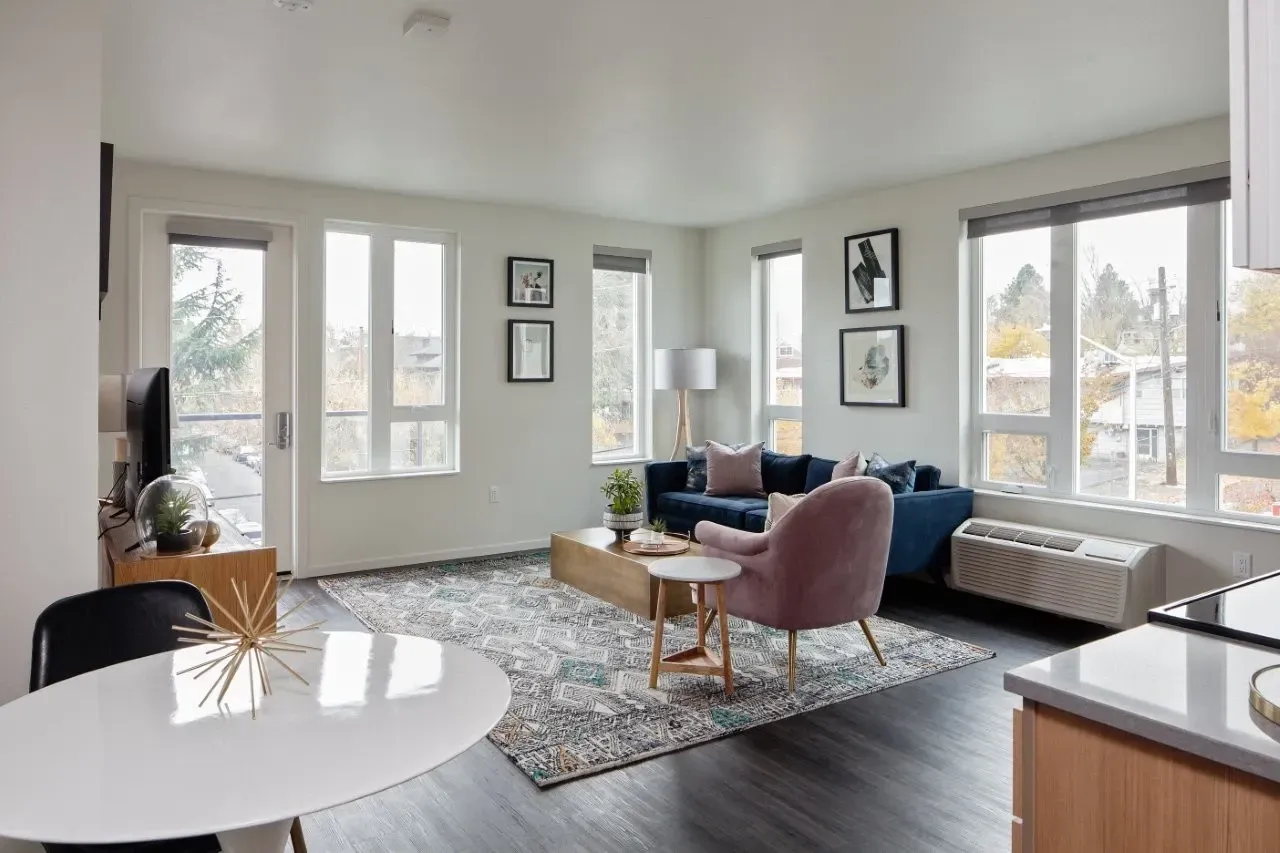 A living room with a white table and a pink chair.