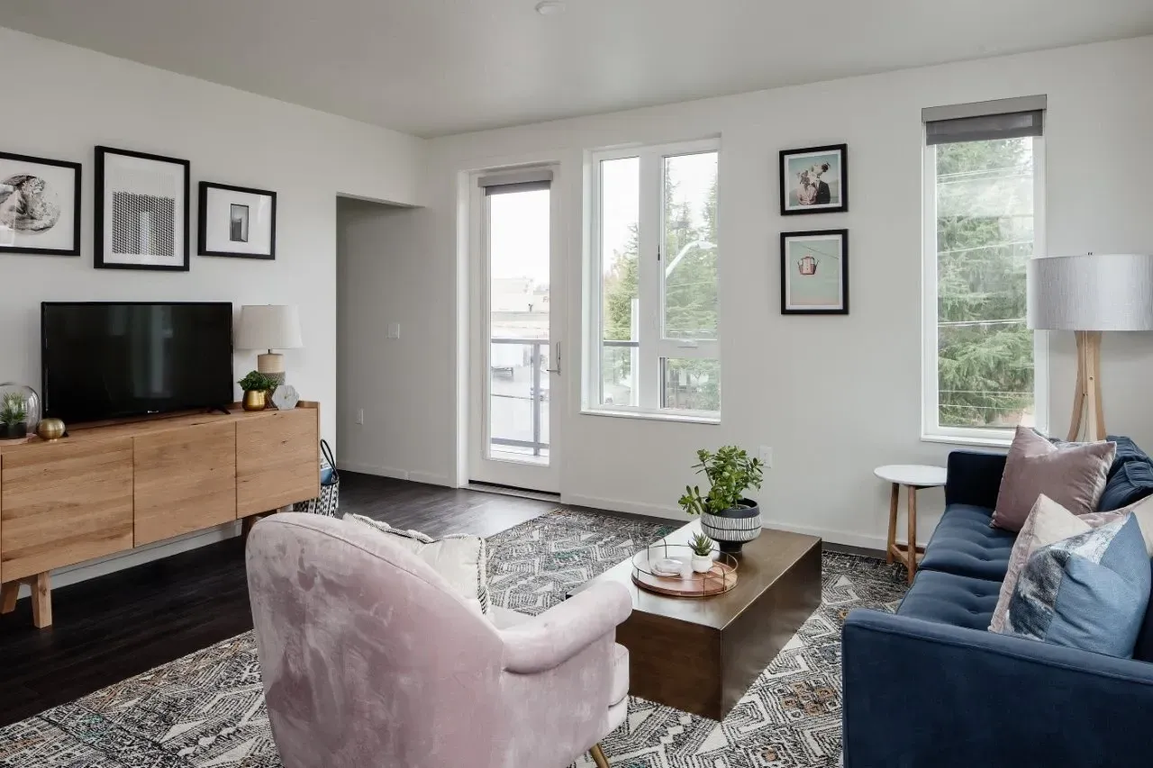 A living room with a pink chair and a blue couch.