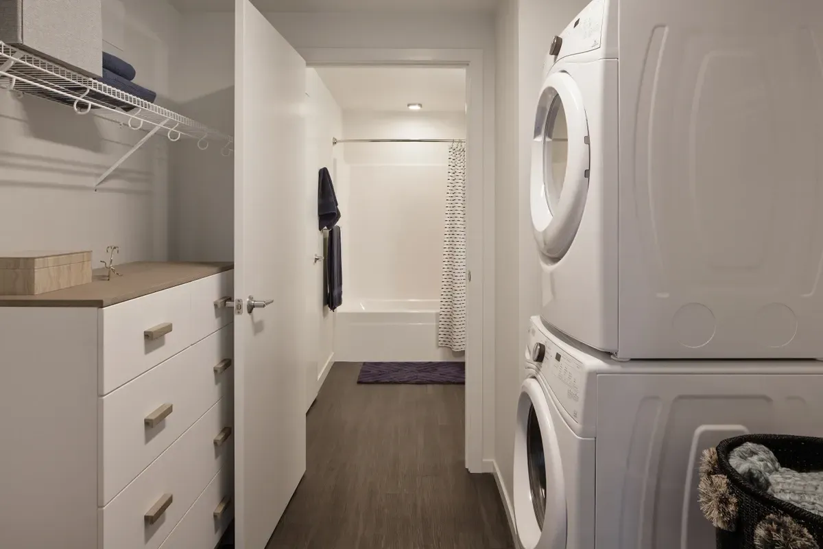 A laundry room with a washer and dryer stacked on top of each other.