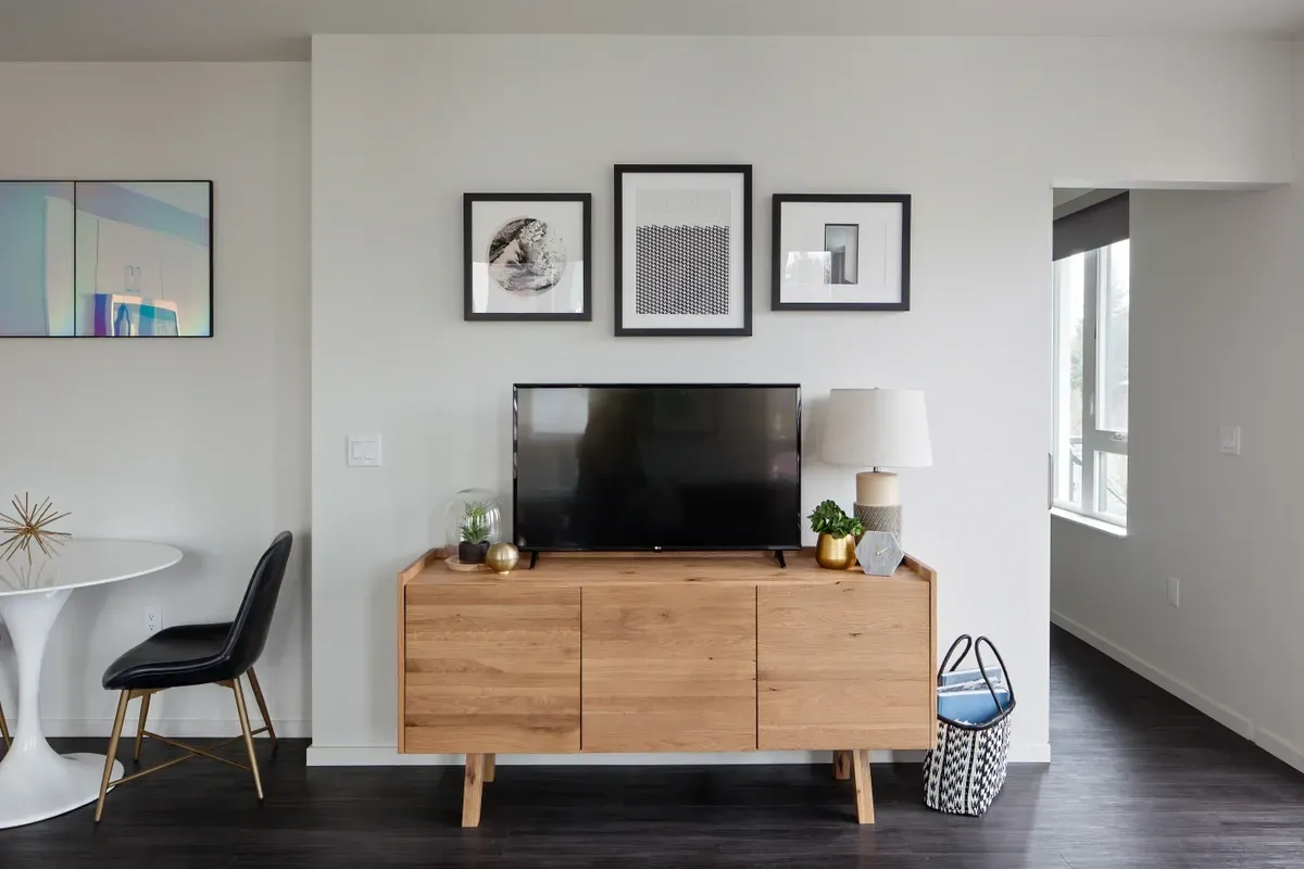 A modern living room with a TV on a wooden cabinet.