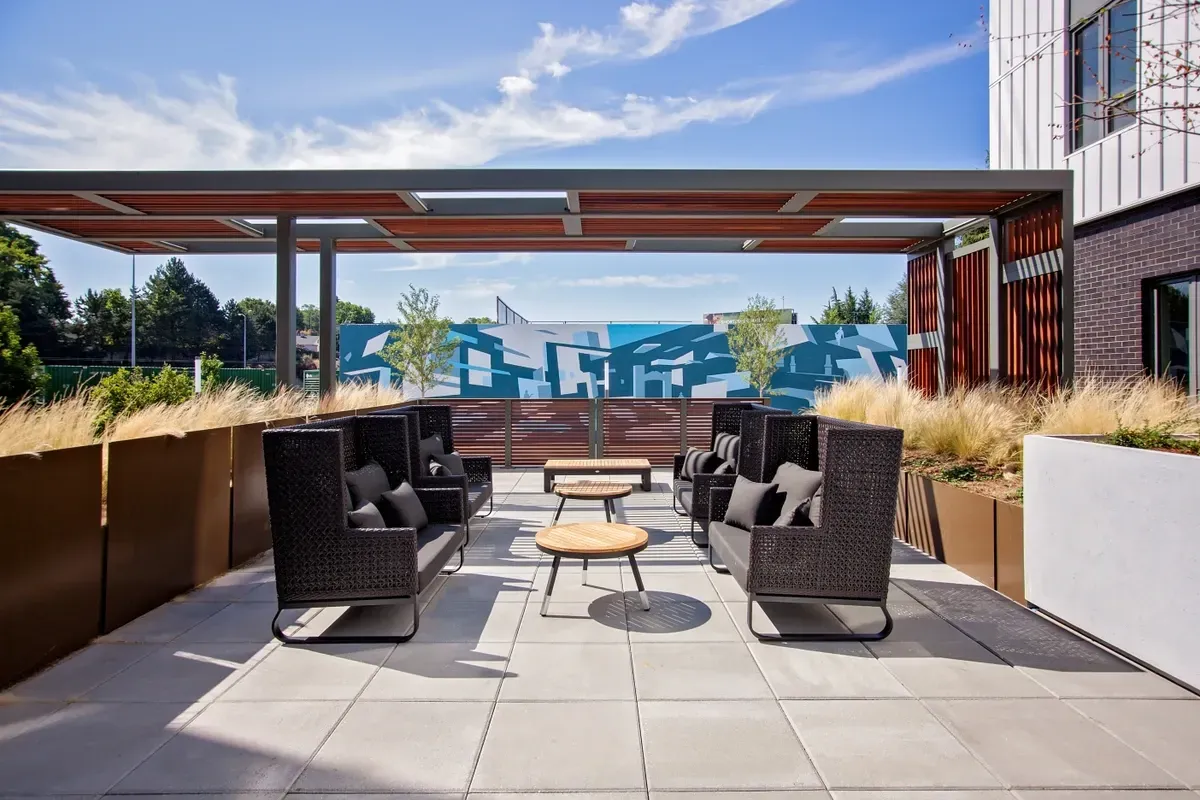 A patio with a table and chairs under a roof.