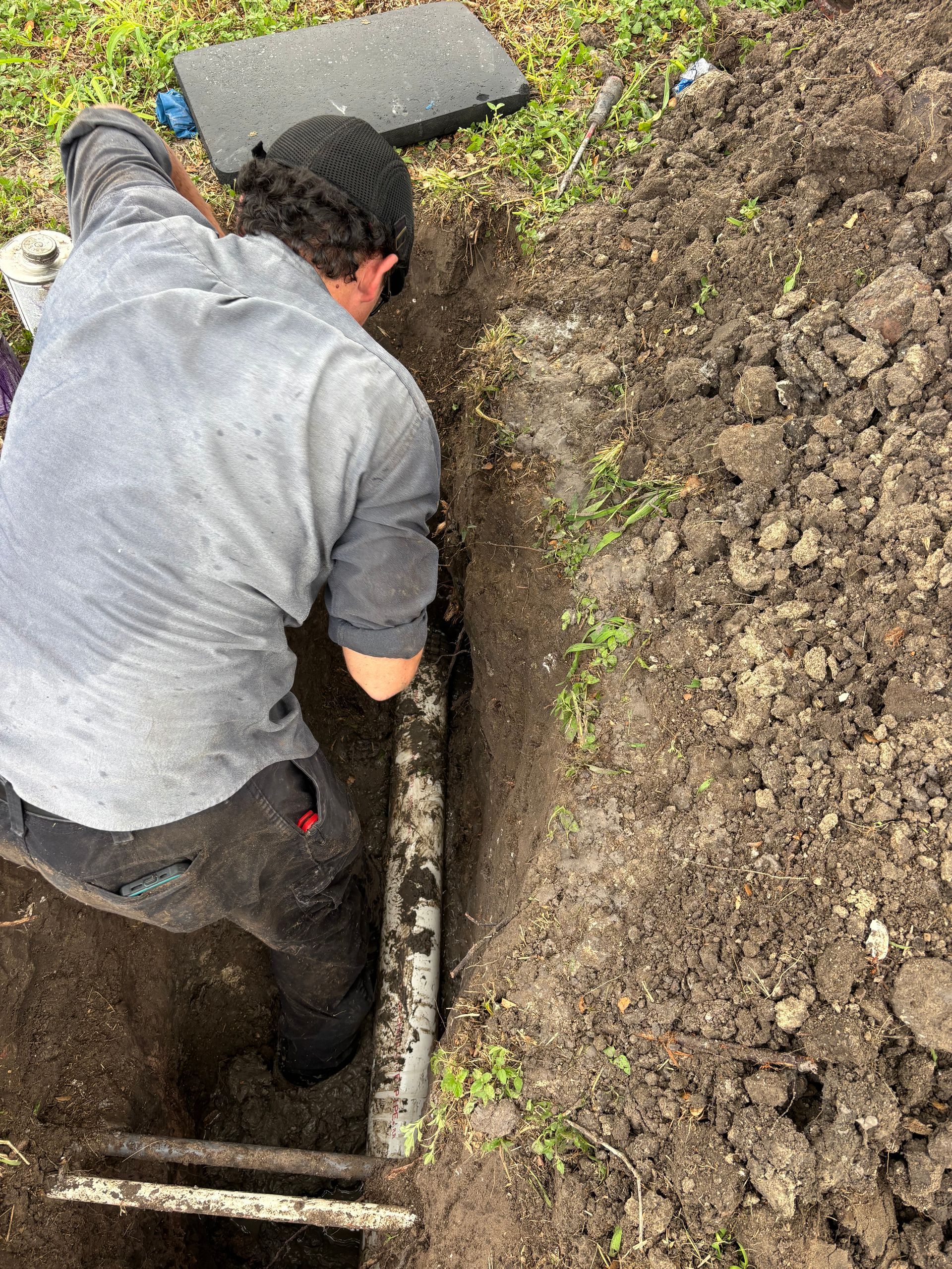 Plumber working on sewer pipes under ground