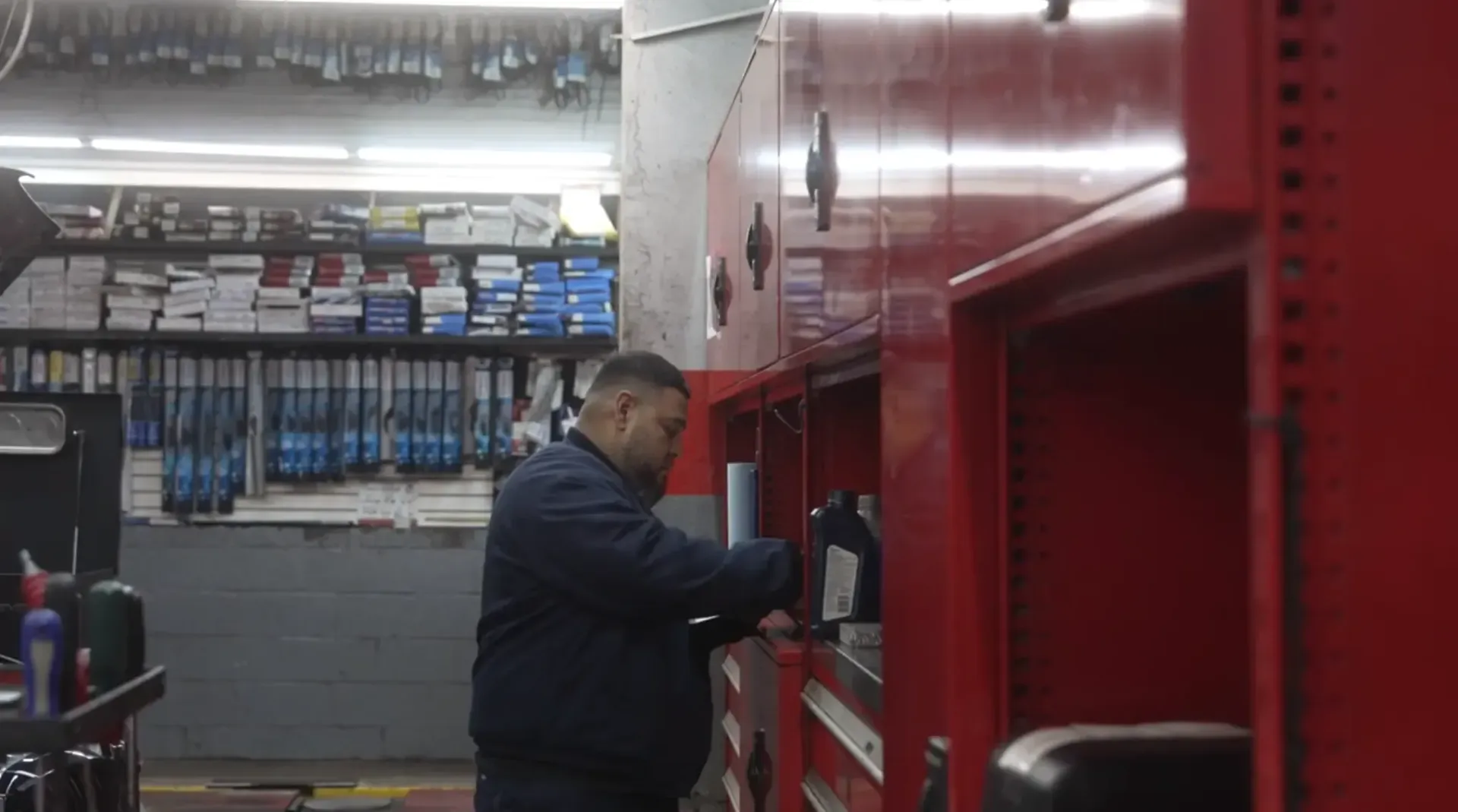 Mechanic working on a red truck in an auto repair shop