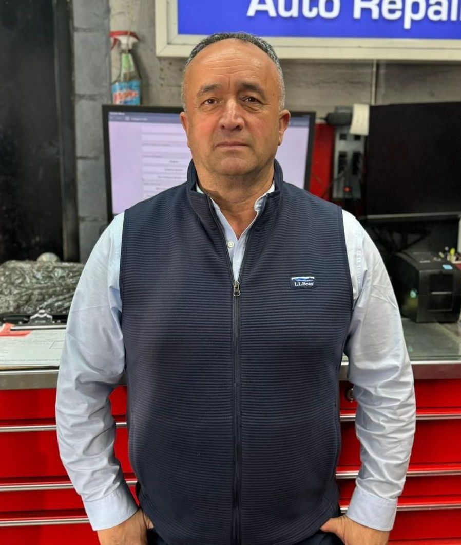 A man is standing in front of a sign that says auto repair for brake repair