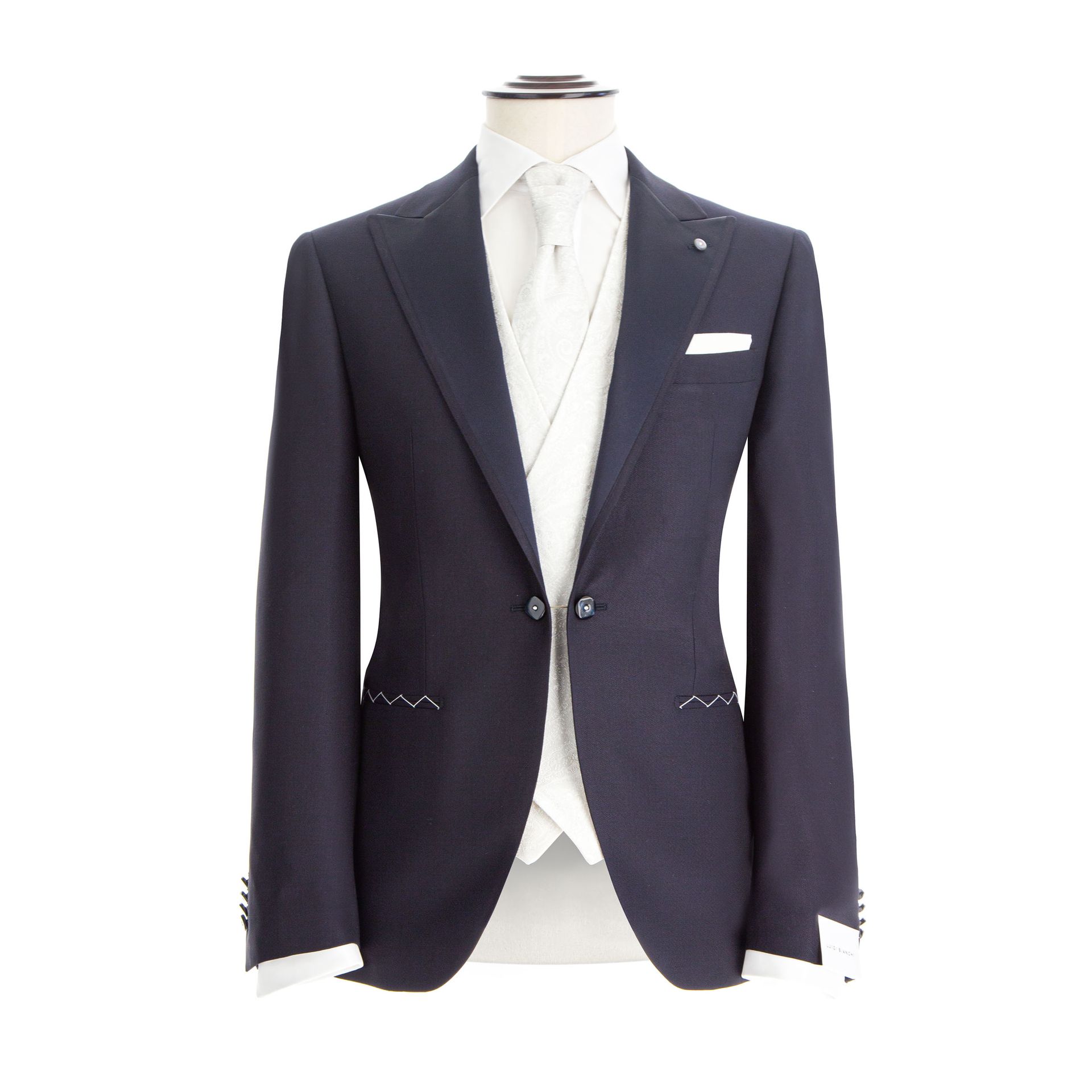 Abito blu navy su manichino, gilet e cravatta bianchi, fazzoletto da taschino.