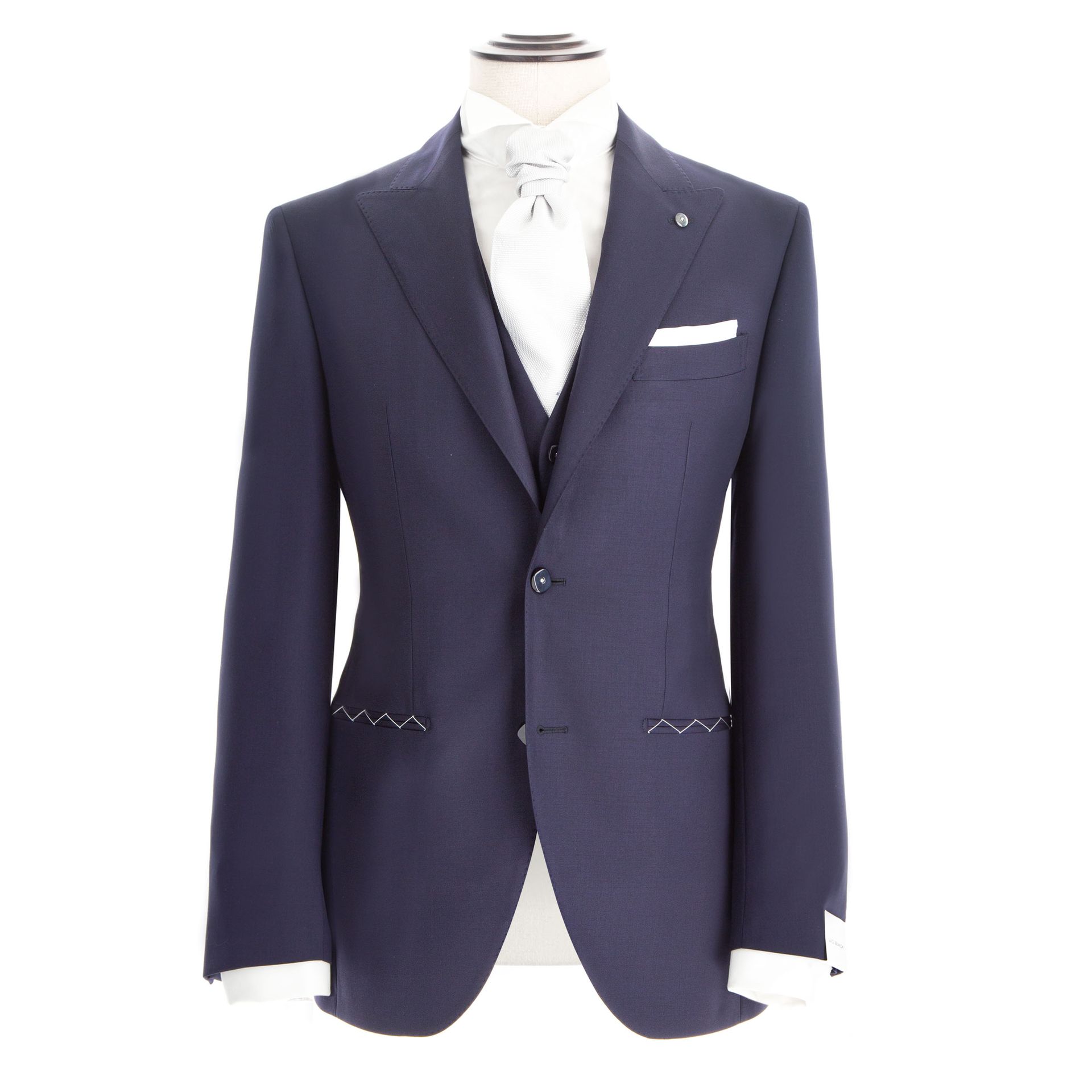 Abito blu navy su manichino con camicia bianca e fazzoletto da taschino.