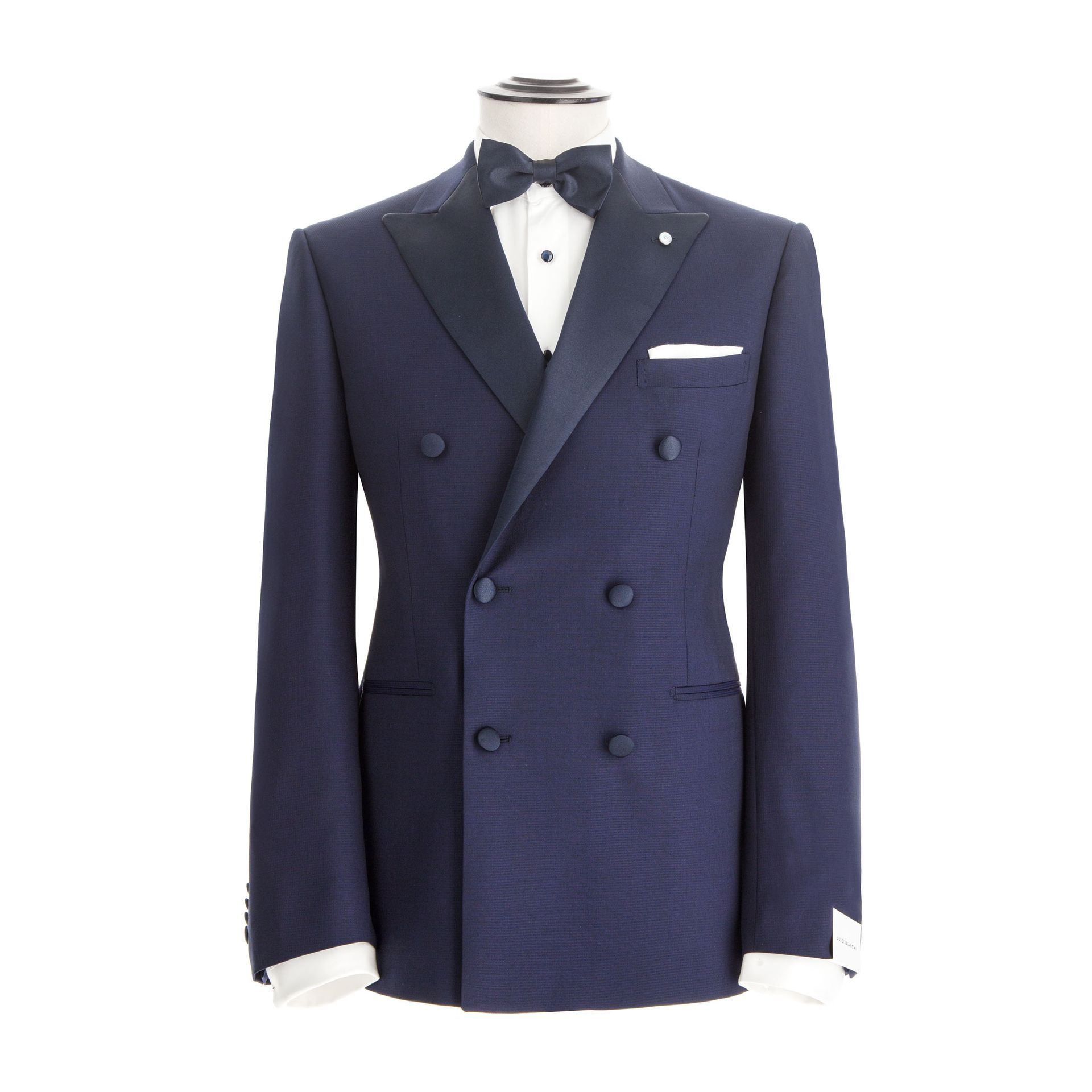 Smoking doppiopetto blu navy su manichino bianco con papillon nero e fazzoletto da taschino bianco.