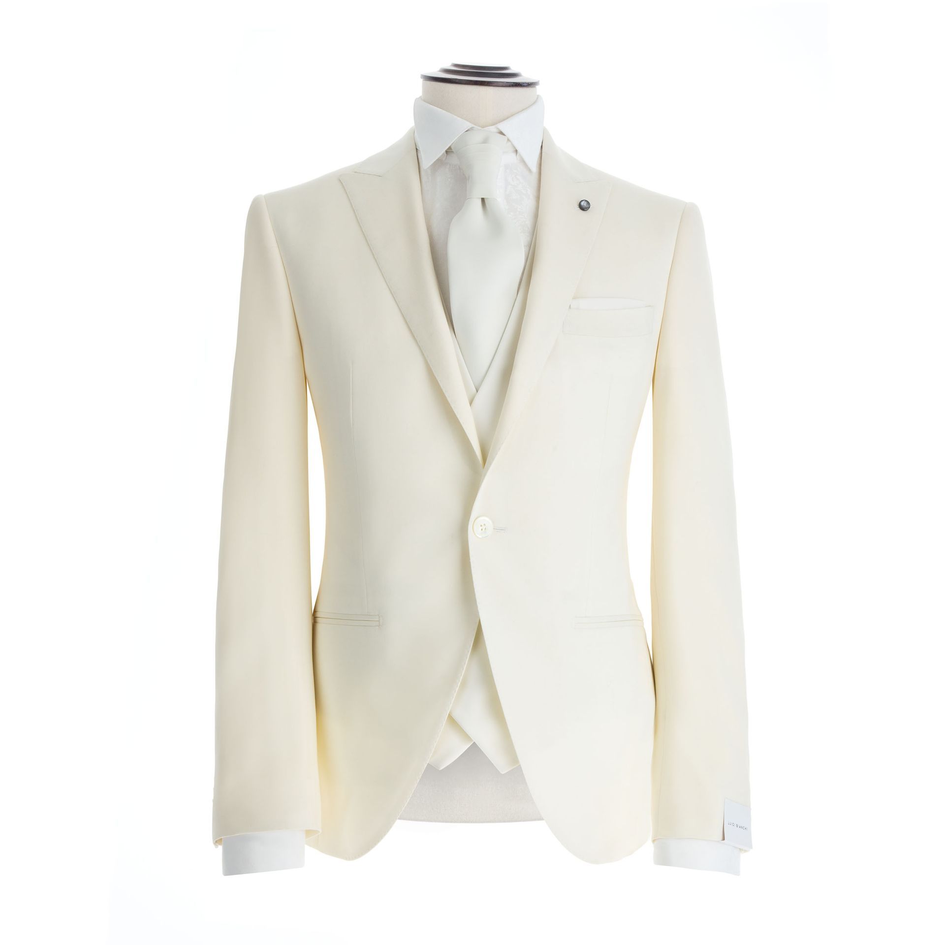 Abito color crema composto da tre pezzi, giacca, gilet e cravatta, indossato su un manichino.