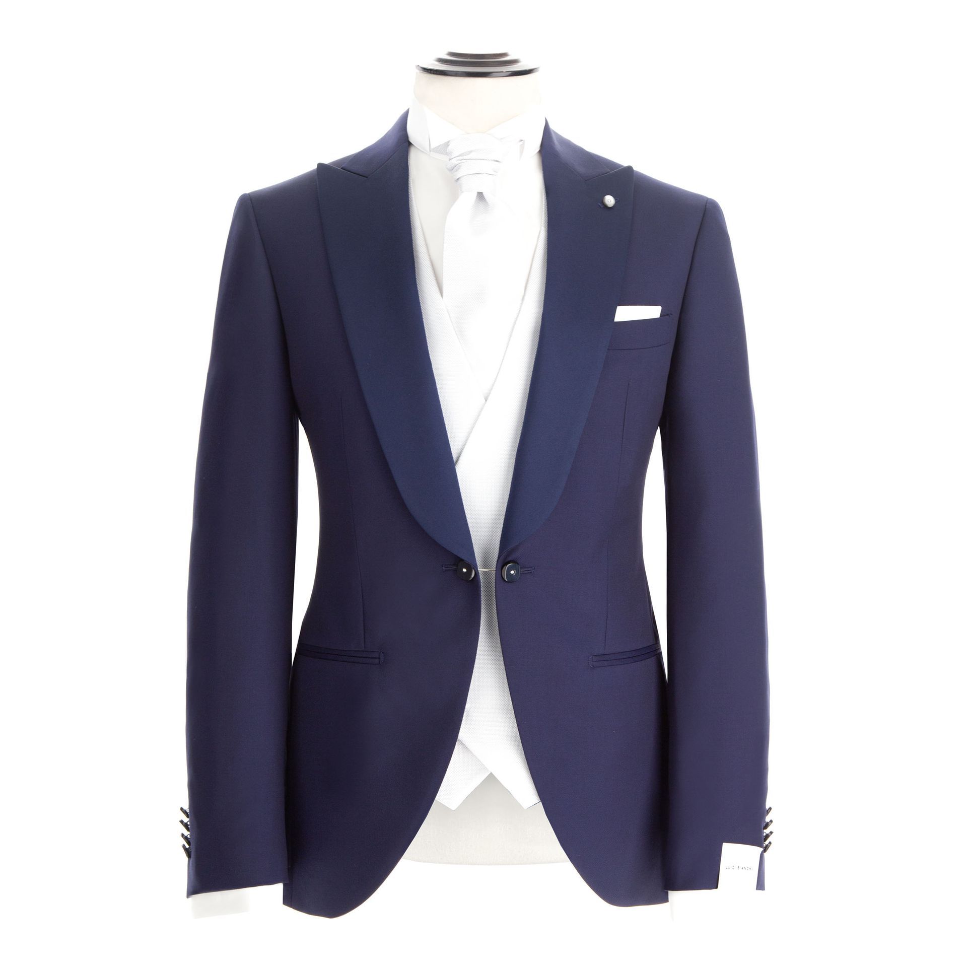 Giacca da smoking blu su manichino, con gilet bianco, cravatta e fazzoletto da taschino.