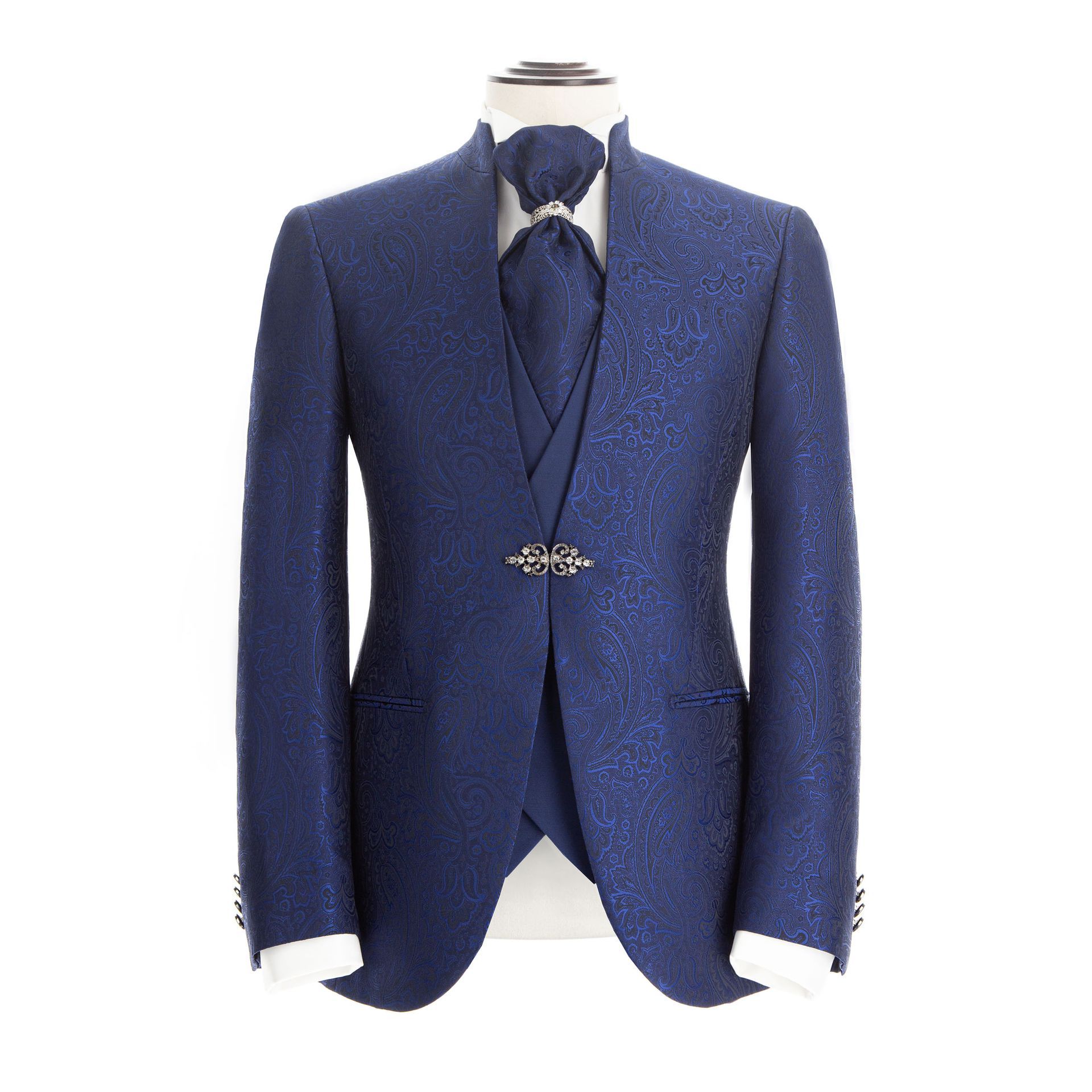Abito blu navy su manichino con motivo paisley, gilet, cravatta e spilla.