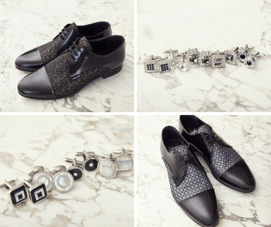 Scarpe eleganti nere a fantasia e un bracciale coordinato color argento e nero, esposti su una superficie di pietra chiara.